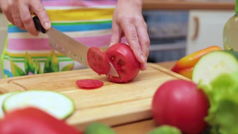 Frauenhände-Hausfrauen-Schneiden-Mit-Einem-Messer-Frische-Tomaten-Auf-Dem-Schneidebrett-Des-Küchentisches